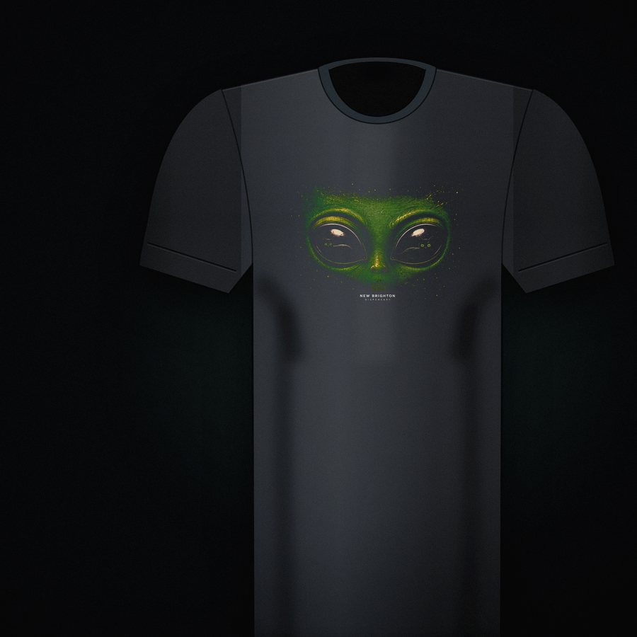 A black tee from MN Dispensary Co. Collection 001, a green alien face printed across the chest